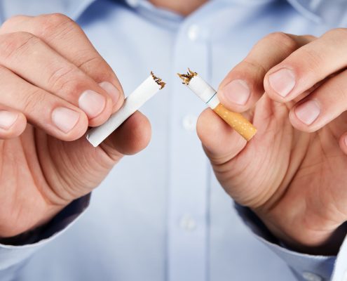 Quit smoking, human hands breaking up cigarette