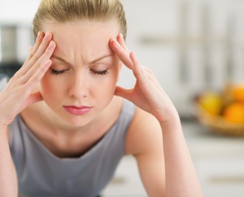 Portrait of stressed young housewife in modern kitchen